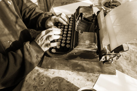 Male writer writing his book on an old antique typewriter. An old antique typewriter.