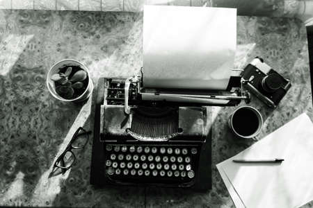 Old antique typewriter with inserted paper for writing articles and books on the desktop.の写真素材