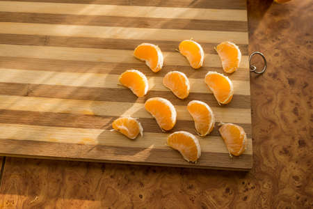 Tangerines and mandarin slices on wooden planks top view.の写真素材