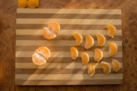 Tangerines and mandarin slices on wooden planks top view.の写真素材