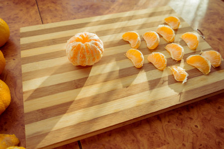 Tangerines and mandarin slices on wooden planks top view.