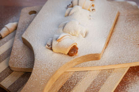 Croissants with apple jam sprinkled with powdered sugar on a wooden background.の写真素材
