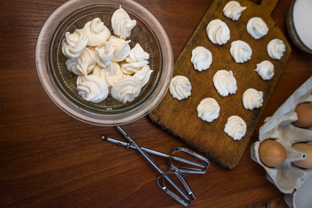 Delicious crispy homemade egg meringue, prepared with love on a wooden background, crunchy dessert...