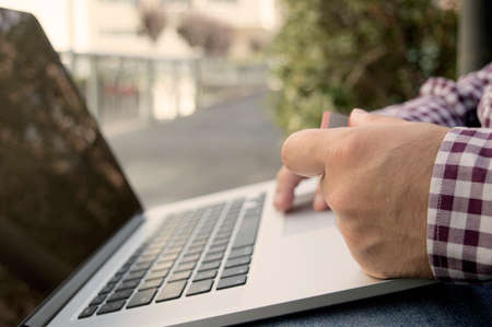 man holding credit card and laptop staying outside and paying or buying online, self-employed, businessman, online businessの写真素材