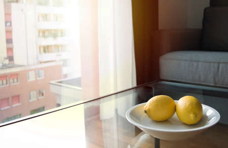 a room with couch big window and glass table during sunsetの写真素材