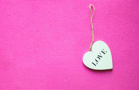 wooden white heart on pink background with copy space の写真素材