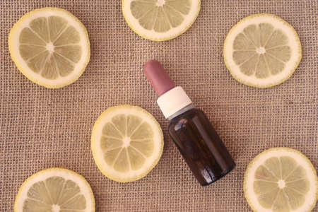 From above citrus oil with slices of lemon on sackcloth backgroundの写真素材