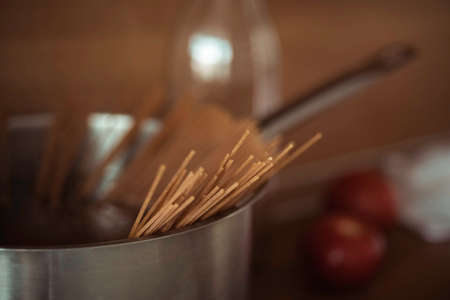 Cooking at home, whole-grained italian pasta on wooden background, clean food, closeup, vegetarian healthy food, lifestyleの写真素材