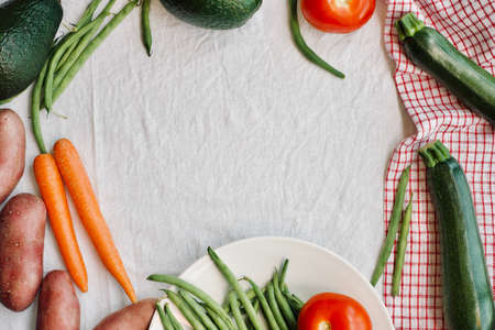 flat-lay with copy space of raw seasonal vegetables over white background. Healthy eating concept, vegetarian, vegan, clean eating.の写真素材