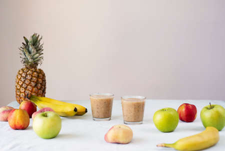 Helathy raw vegan food cooking background. Fresh fruits and smoothies on table over white table cloth. Clean eating, alkaline diet conceptの写真素材