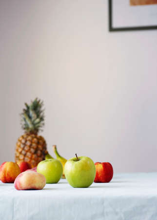 Helathy raw vegan food cooking background. Fresh fruits and smoothies on table over white table cloth. Clean eating, alkaline diet conceptの写真素材