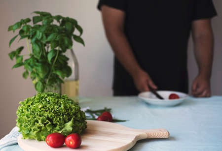 young man cooking healthy vegetarian food indoor. Healthy Italian food concept, diet, detoxの写真素材