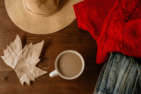 flat lay of autumn fall warm clothes cup of coffee and autumn leaf over wooden background. Autumn fall cozy concept 
の写真素材