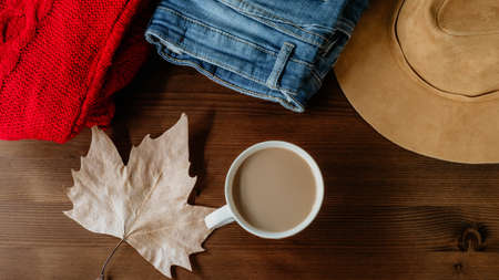 flat lay of autumn fall warm clothes cup of coffee and autumn leaf over wooden background. Autumn fall cozy conceptの写真素材