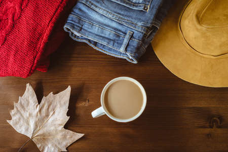 flat lay of autumn fall warm clothes cup of coffee and autumn leaf over wooden background. Autumn fall cozy conceptの写真素材