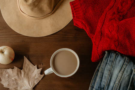 flat lay of autumn fall warm clothes cup of coffee and autumn leaf over wooden background. Autumn fall cozy conceptの写真素材