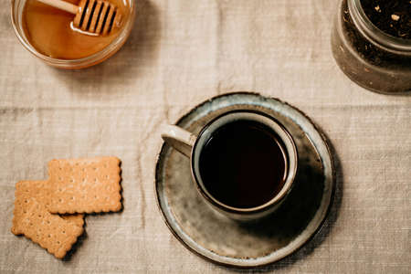 top view cozy seasonal fall or winter breakfast with hot drink honey and biscuits cookies over tableclothの写真素材