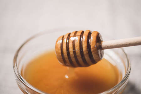 honey with spoon in glass bowl close up selective focus, healthy vegetarian vegan sweets, foodの写真素材