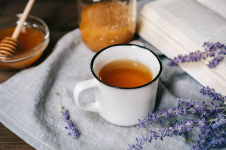 cup of herbal tea with sage and honey with spoon in glass bowl over rustic wooden background, healthy drinkの写真素材
