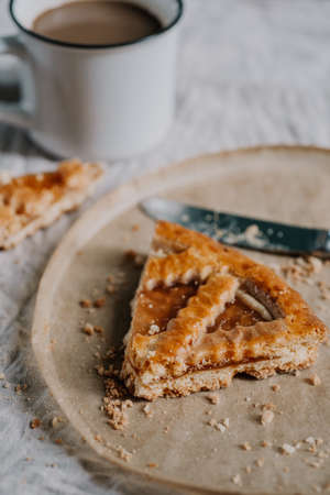 autumn fall crust pie with jam close up selected focus with cup of coffee on backgroundの写真素材