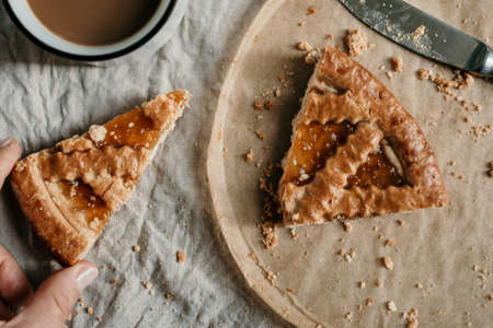 autumn fall crust pie with jam close up selected focus with cup of coffee on backgroundの写真素材