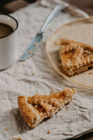 autumn fall crust pie with jam close up selected focus with cup of coffee on backgroundの写真素材