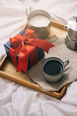 Romantic breakfast with coffee and milk served on tray and gift box valentine's day or holiday conceptの写真素材