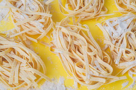 flat lay of home made pasta ingredients cooking noodles or pasta at home. Texture, yellow backgroundの写真素材