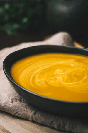 vegeratian creamy soup in bowl over rustic background, Top view, healthy eating seasonal foodの写真素材