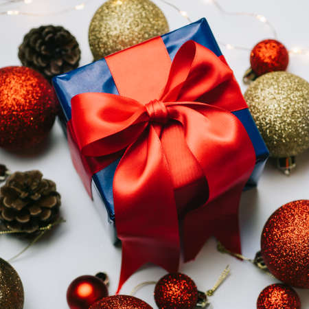 square croped flat lay of christmas decoration and christmas box gift present with red ribbon over white background. Golden and red christmas conceptの写真素材