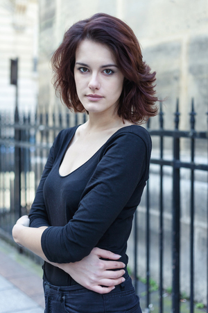 Beautiful young girl with dark hair in the street.の写真素材