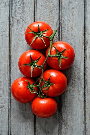 Group of ripe tomatoes on a rustic wooden table. View from aboveの写真素材