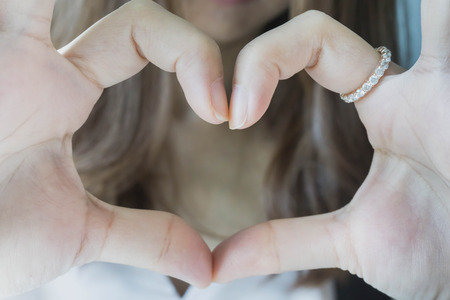 Young girl's hands making heart shape for valentine day.の写真素材