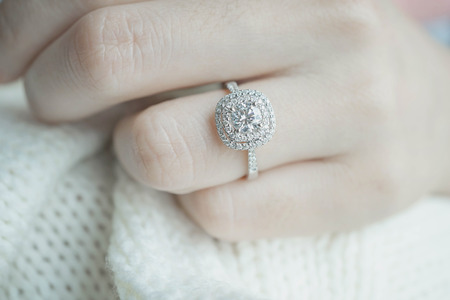 Close up Diamond ring on woman's finger before wedding with white scarf background.(soft and selective focus)の写真素材