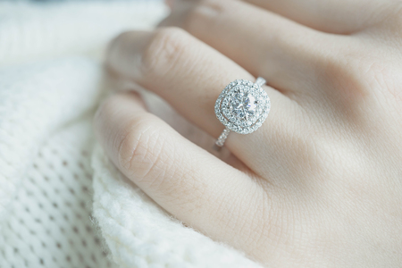 Close up Diamond ring on woman's finger before wedding with white scarf background.(soft and selective focus)の写真素材
