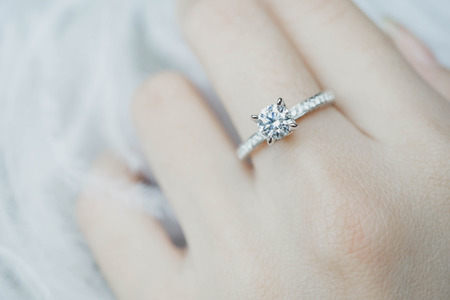Close up of elegant diamond ring on the finger with gray Scarf background. Diamond ring.の写真素材