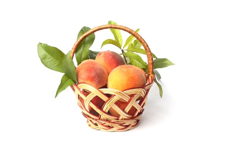 peaches in a basket isolated on whiteの写真素材