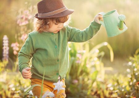 The little girl with the watering can in the gardenの写真素材