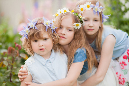 horizontal photo of a cute lovely little sisters in the garden full of flowersの写真素材