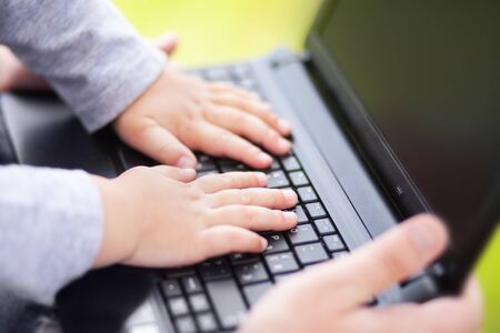 Closeup photo of little kid working with laptop.の写真素材