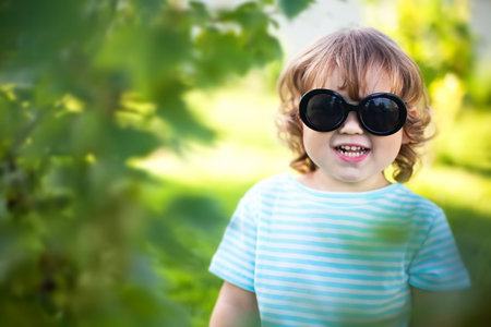 Adorable toddler kid wearing sunglasses outdoors, hot summer dayの写真素材