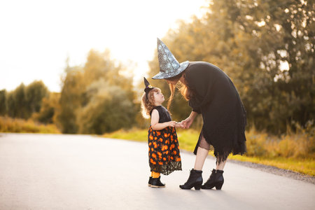 Mother and child dressed in halloween witch costumes. copycspace, empty space for text.の写真素材