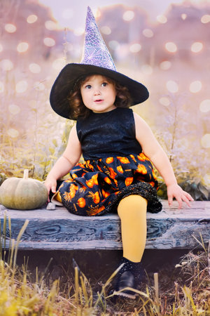 Toddler girl ready for halloween and trick or treat. Adorable little witch. Toned in blue and yellow, happy halloween, art photo.の写真素材