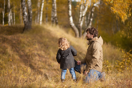 Father and his little daughter together in the wild forest, autumnの写真素材