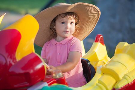 toddler kid ride electric taxi car attraction, having fun at summer day, lifestyle. theme park for children, vacationの写真素材