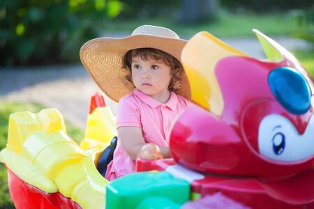 toddler kid ride electric taxi car attraction, having fun at summer day, lifestyle. theme park for children, vacationの写真素材