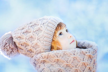 Cute toddler girl outdoors on a sunny winter day, walking, snowy dayの写真素材