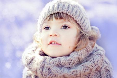Cute toddler girl outdoors on a sunny winter day, walking, snowy dayの写真素材