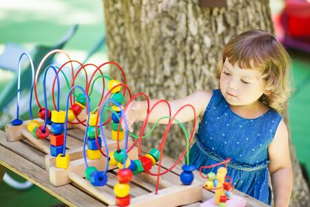 little girl playing with educational toy - labyrinth. kindergarten concept, lifestyle. Early education and development.の写真素材