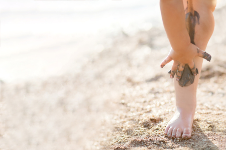 Legs covered with black health mud, outdoors, closeupの写真素材